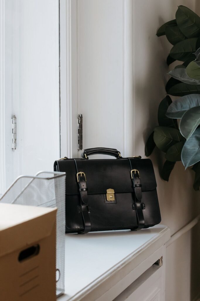A leather briefcase packed and waiting by an office door