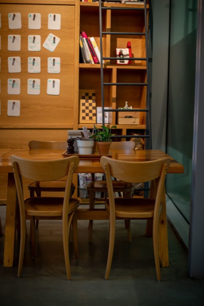 A warm office corner with a wooden table, chairs and a shelf